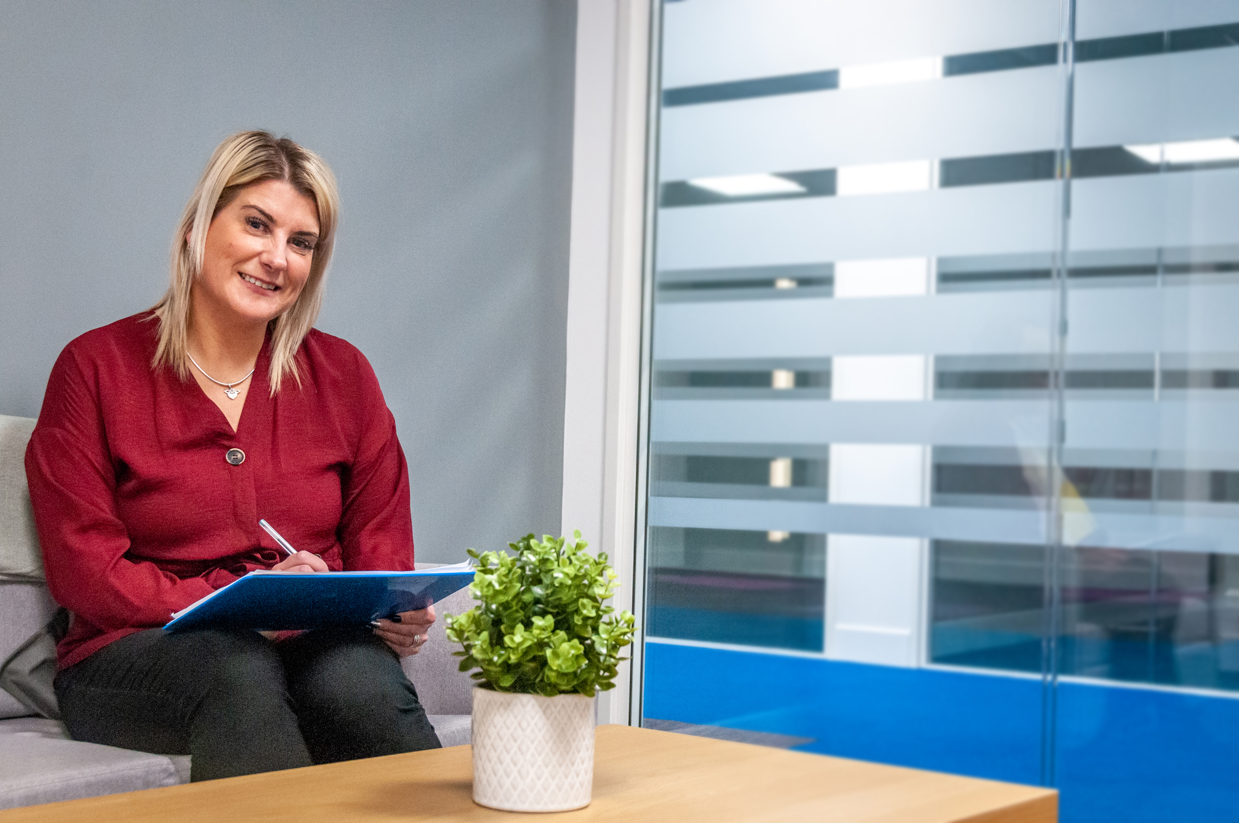 Female Counsellor sitting on sofa with clipboard
